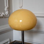 Close-up of the rounded cream glass mushroom shade and polished chrome stem.