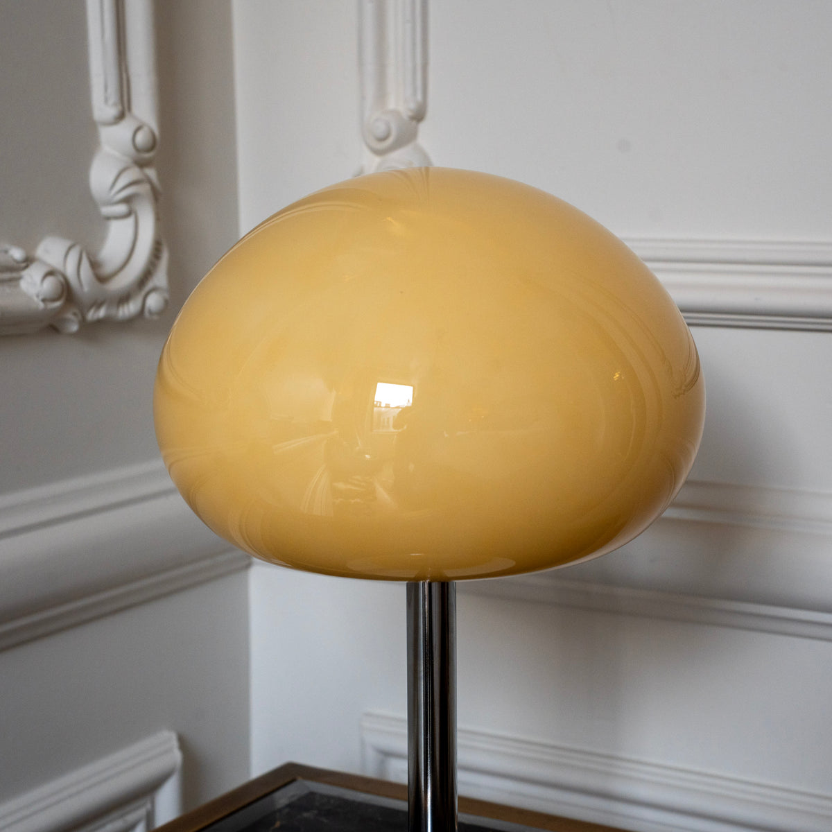 Close-up of the rounded cream glass mushroom shade and polished chrome stem.