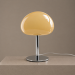 Cream glass mushroom table lamp with a polished chrome stem and round base on a neutral studio backdrop.
