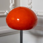 Close-up of the glossy orange glass mushroom shade with a polished chrome stem.