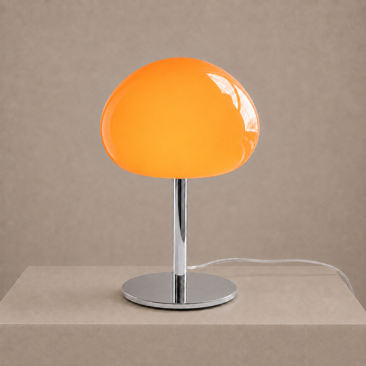 Illuminated orange glass mushroom lamp casting a warm glow on a neutral studio backdrop.