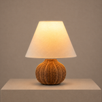 illuminated woven rattan table lamp with a warm glow and white fabric shade