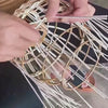 Behind-the-scenes video showing an Ora Collective Home light being handmade, with woven material carefully shaped and assembled by hand.